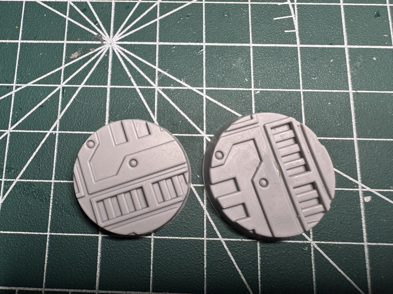 Two allegedly identical 25 mm bases side by side
